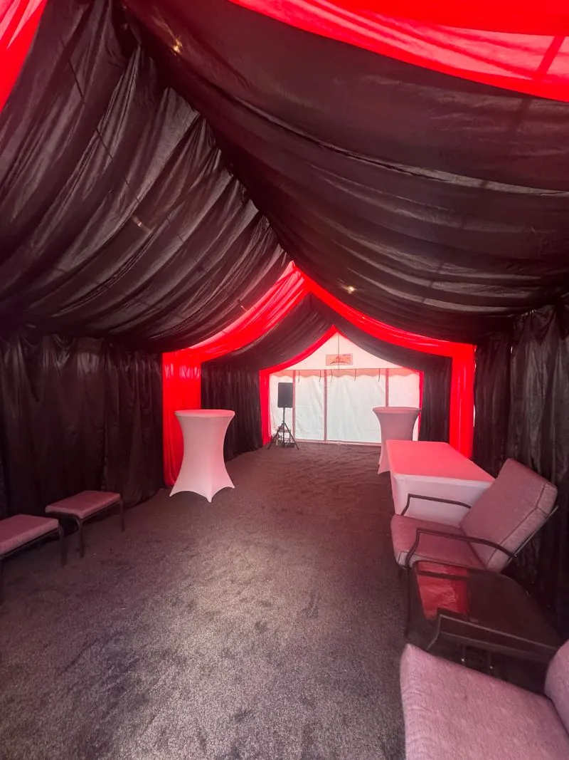 Black and Red Party Marquee Interior with Drapes and Lighting Black and red party marquee interior with draped ceiling, red lighting, cocktail tables and lounge seating