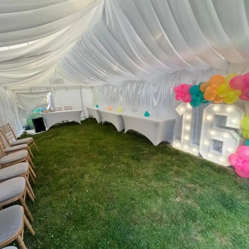 Ivory Draped Marquee Birthday Setup With Balloon Display Ivory draped marquee birthday setup with balloon display and illuminated number 16