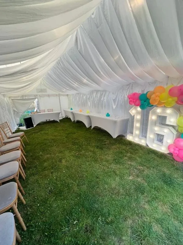 Ivory Draped Marquee Birthday Setup With Balloon Display Ivory draped marquee birthday setup with balloon display and illuminated number 16