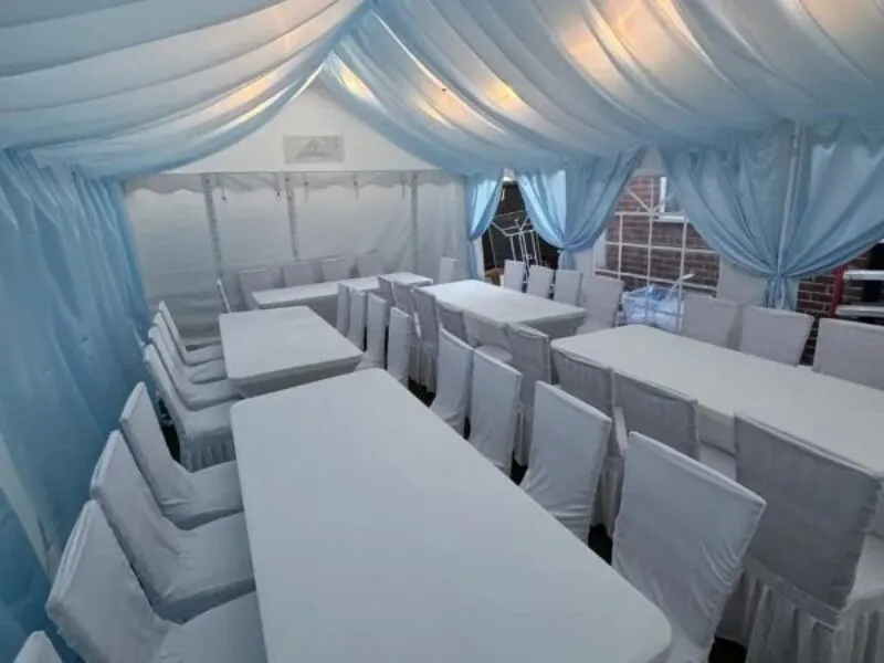 Blue Draped Marquee Dining Layout Essex Marquee with blue draping and banquet dining table layout with covered chairs