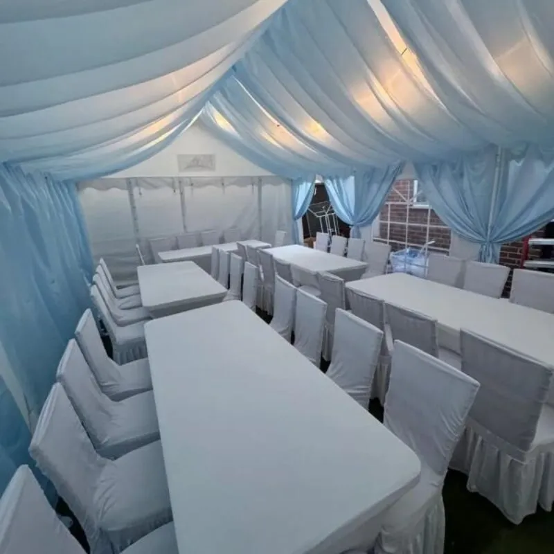 Blue Draped Marquee Dining Layout Essex Marquee with blue draping and banquet dining table layout with covered chairs