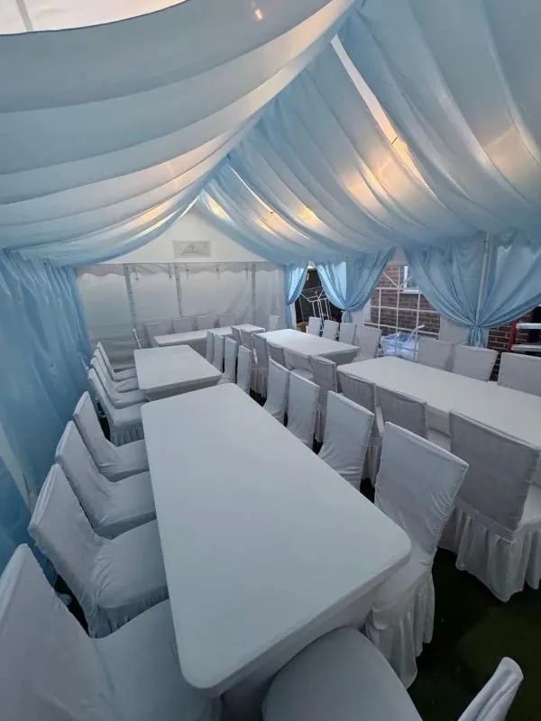 Blue Draped Marquee Dining Layout Essex Marquee with blue draping and banquet dining table layout with covered chairs