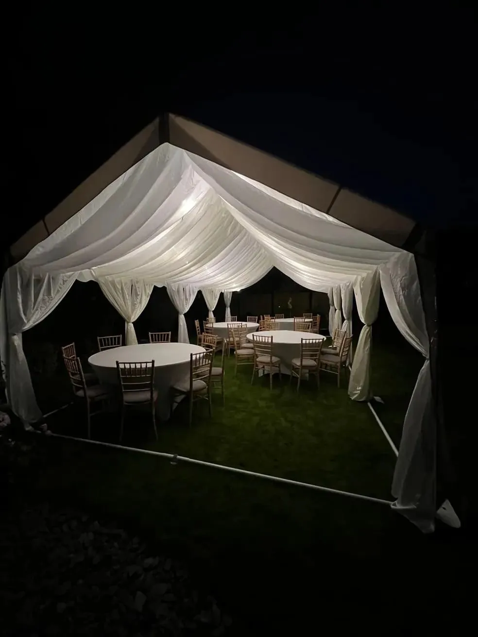 Evening Wedding Marquee With Round Tables And Lighting Evening wedding marquee with ivory draping, round tables and soft interior lighting