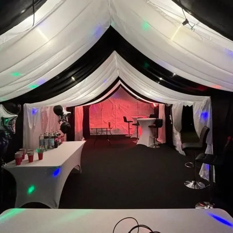 Party marquee with bar setup, drinks table and coloured lighting