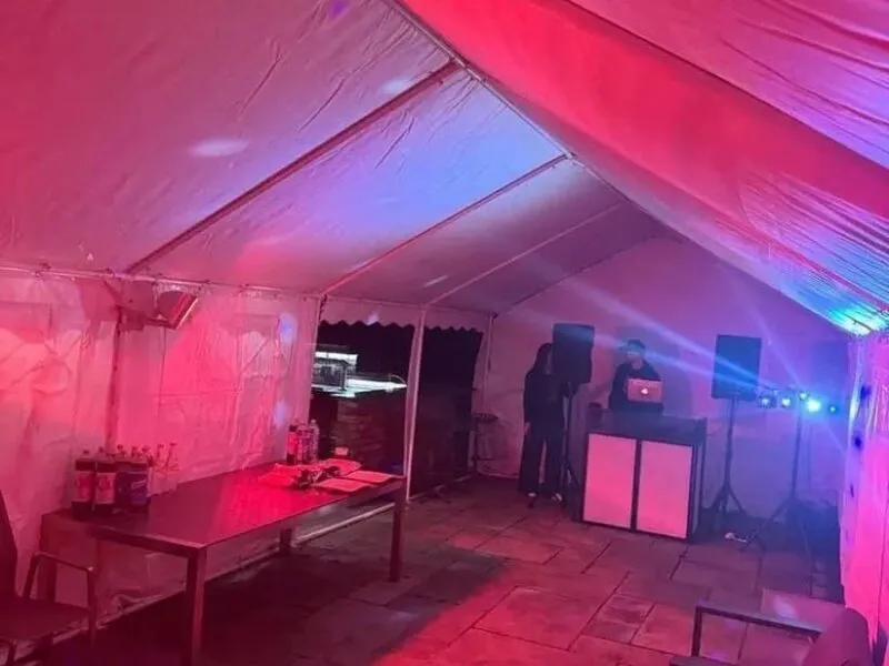 Party Marquee With DJ And Lighting Setup Essex Party marquee with DJ booth, coloured lighting and drinks table setup
