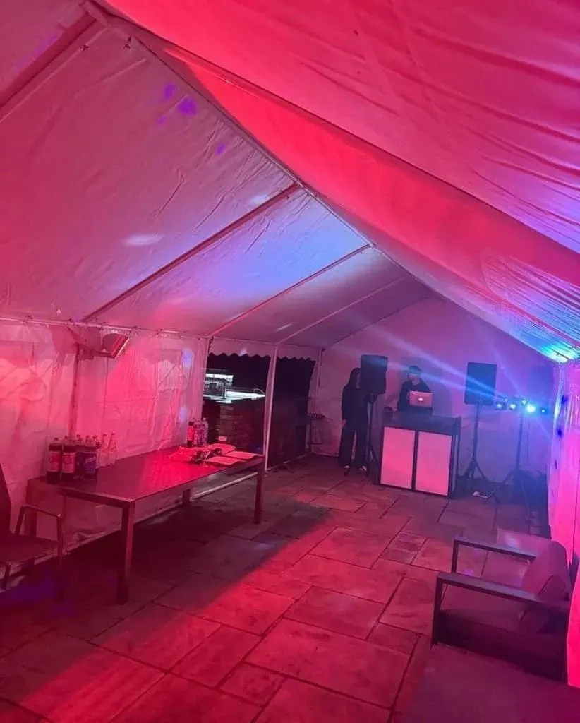 Party Marquee With DJ And Lighting Setup Essex Party marquee with DJ booth, coloured lighting and drinks table setup