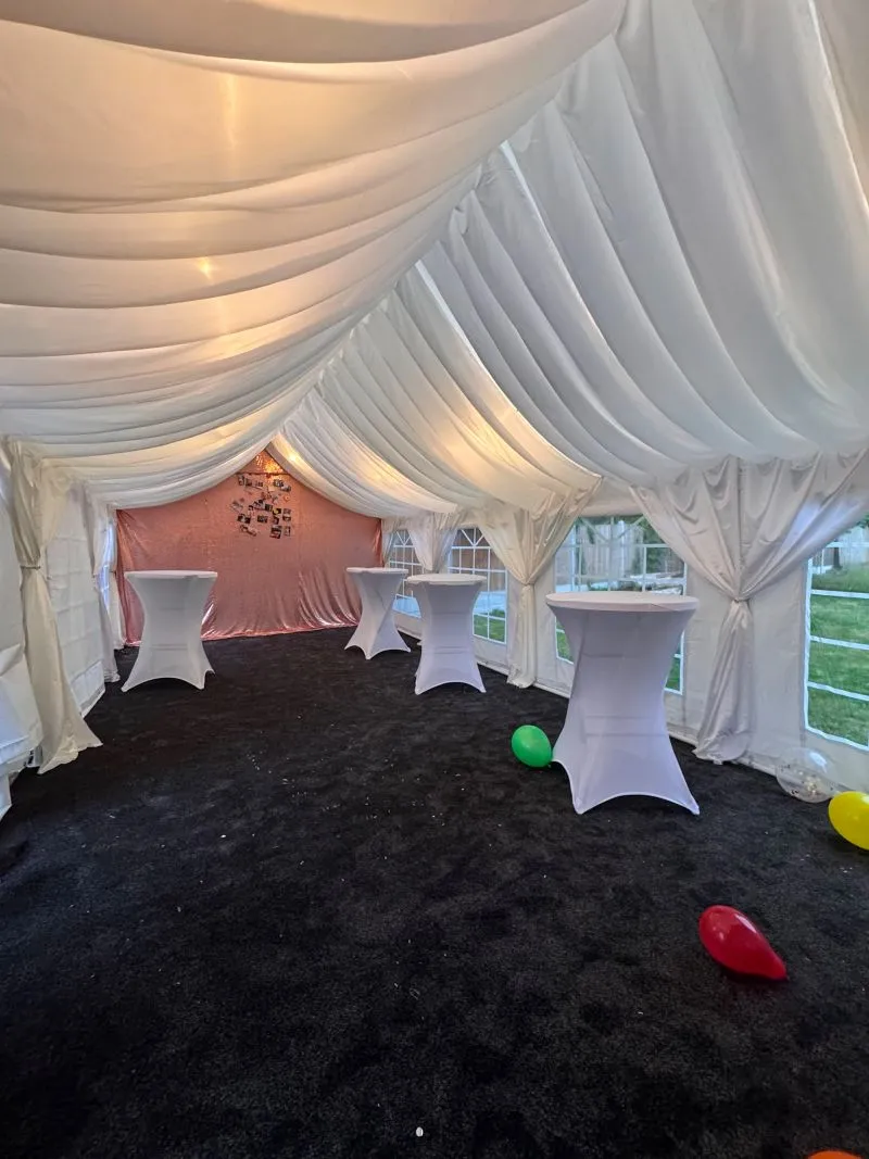 White Party Marquee Interior with Cocktail Tables White party marquee interior with draped ceiling, cocktail tables, black carpet and balloons