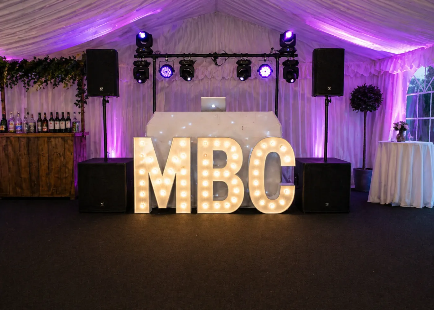 DJ Hire Essex – Marquee DJ Setup with Dancefloor and Lighting DJ hire setup in Essex marquee with speakers, lighting, illuminated letters and dancefloor for party event