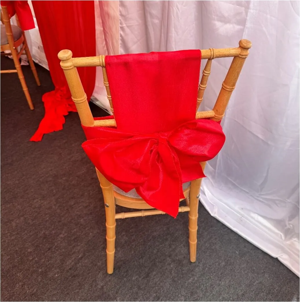 Chair Bow Detail – Forest Gate Marquee Setup Chiavari chair with red bow detail inside marquee in Forest Gate during family event setup