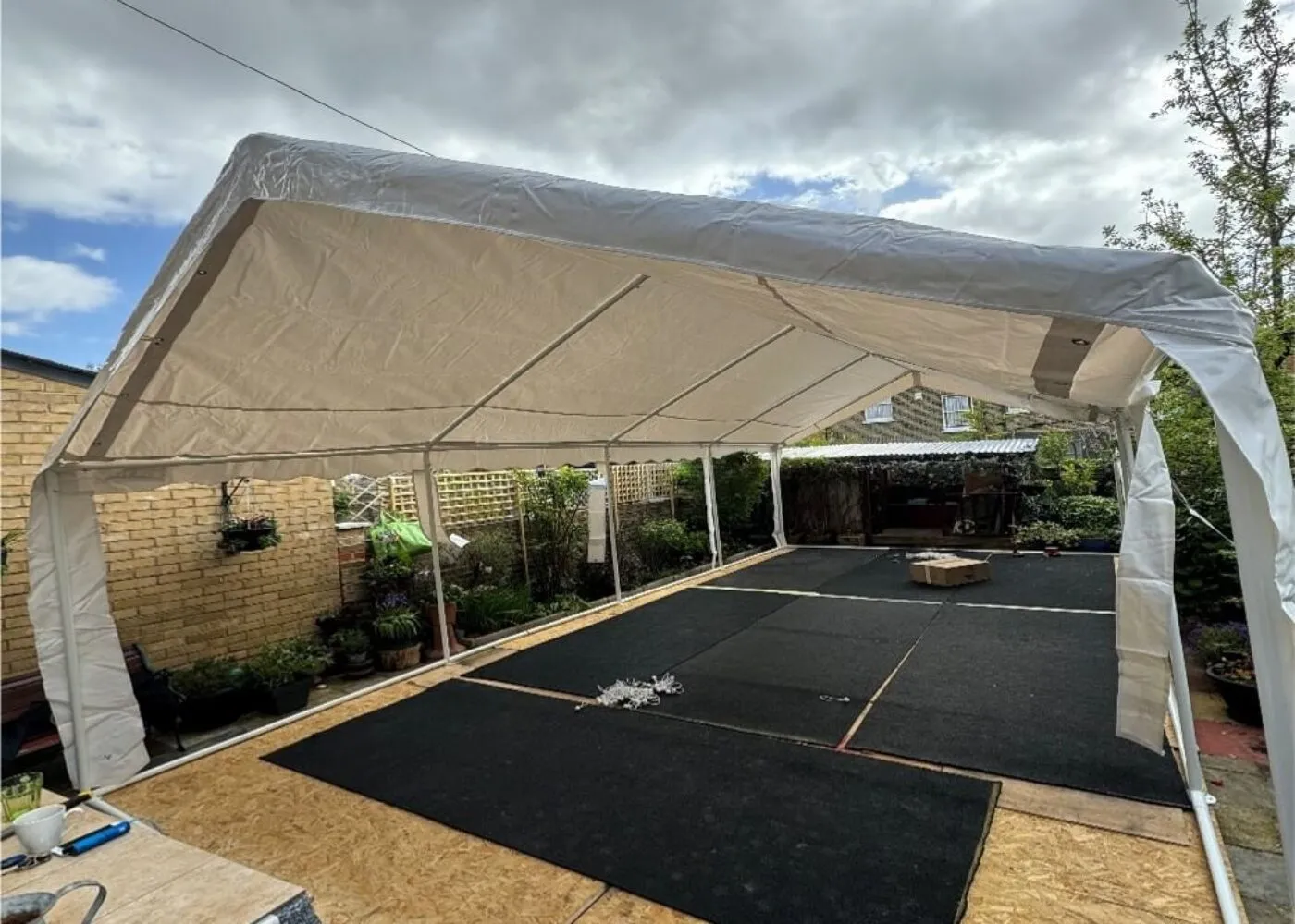 Marquee Structure Installation – Forest Gate Garden Setup 4m x 8m marquee structure installation in Forest Gate garden with flooring and frame setup in progress