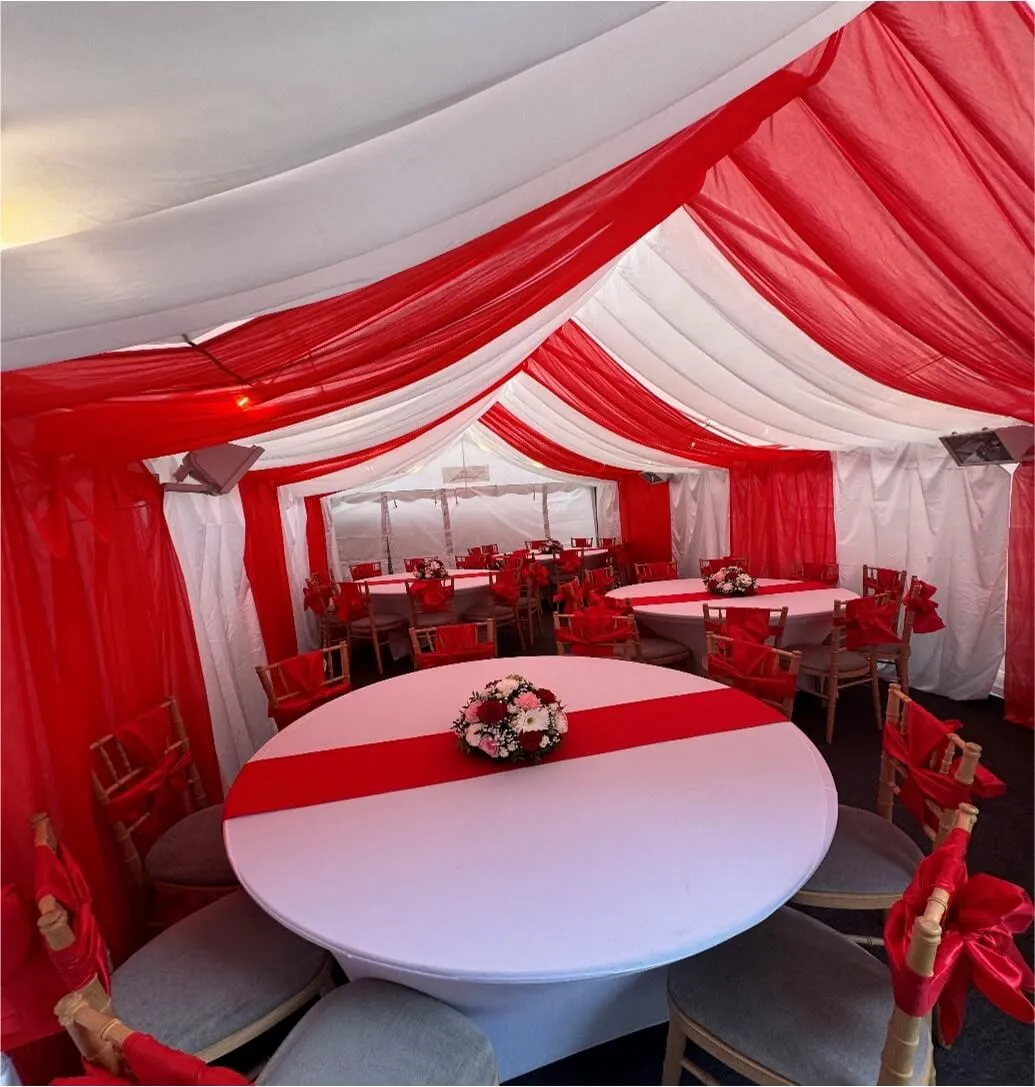 Red Themed Marquee Interior – Forest Gate Event Setup 4m x 8m marquee interior in Forest Gate with red and white draped lining, round table layout and Chiavari chairs for family event