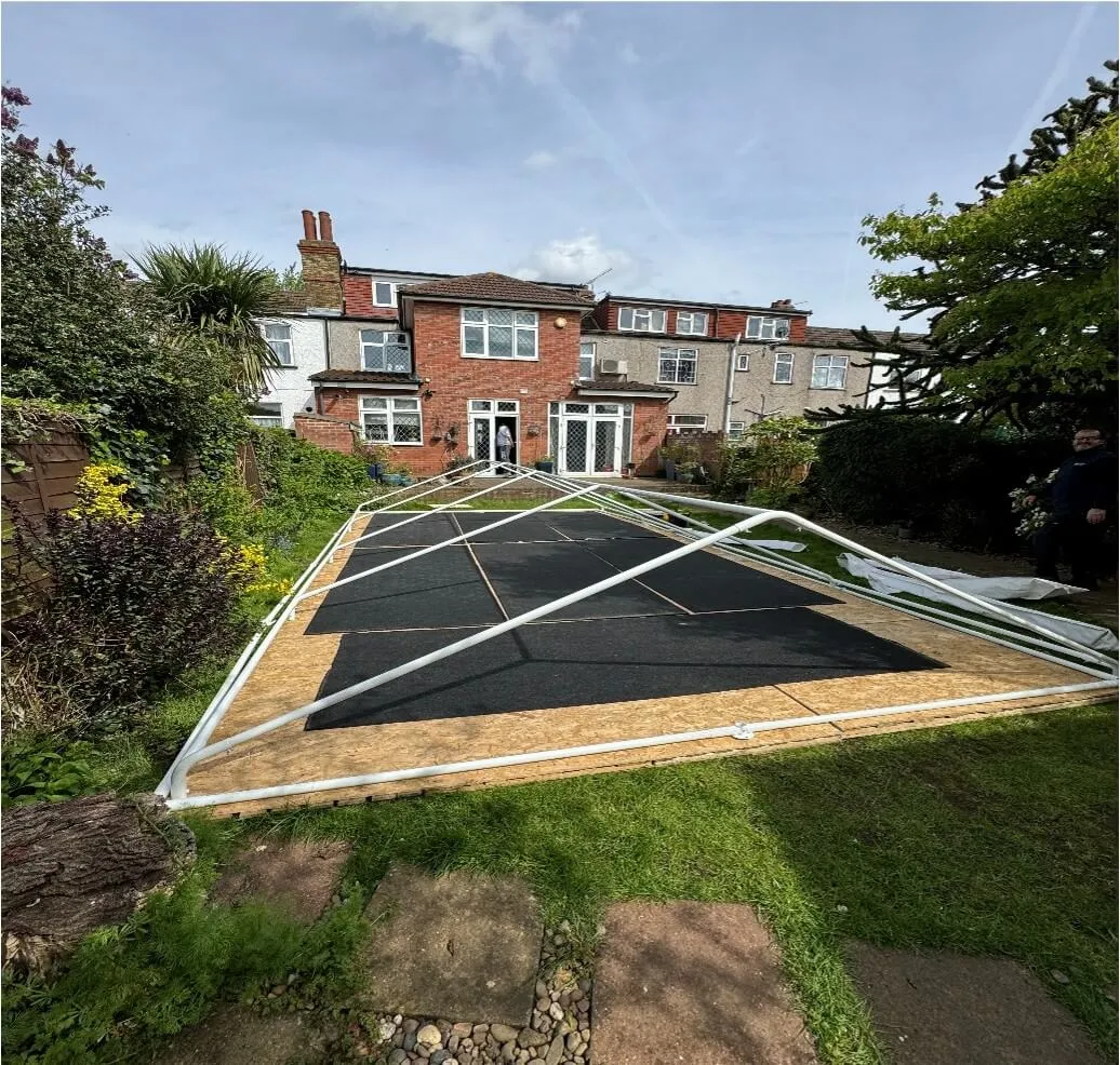 Marquee Frame Preparation – Tilbury Garden Installation Marquee frame laid out on flooring during installation stage in Tilbury garden before assembly