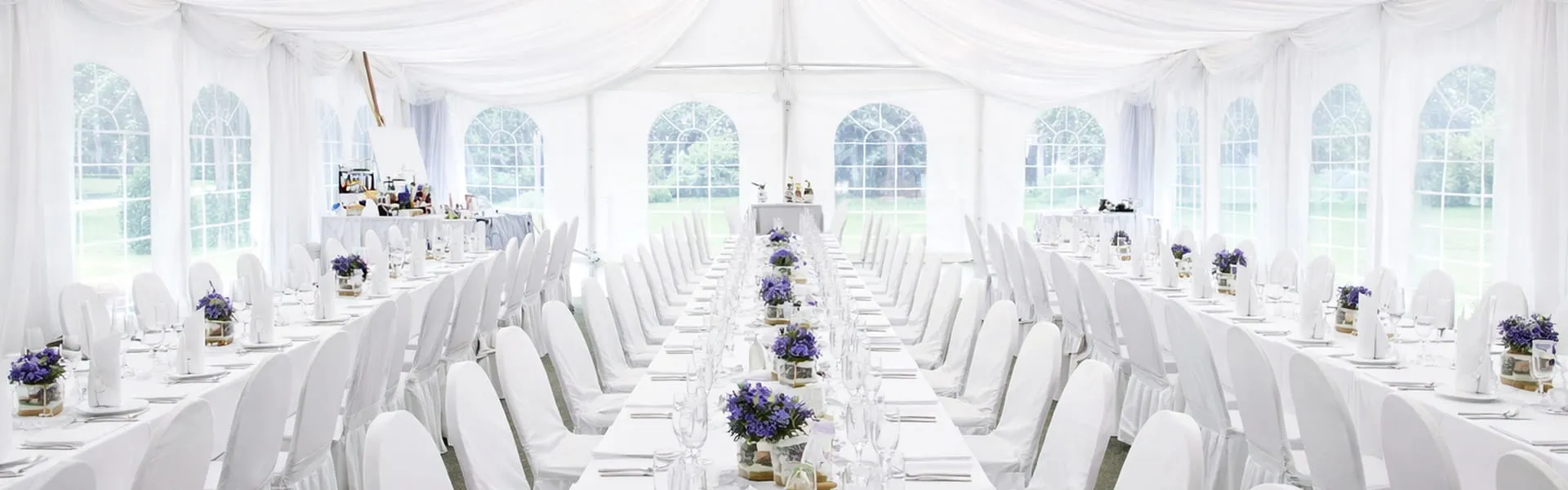 Marquee Event Setup With Table Layout For Company Updates Marquee interior with long table layout and covered chairs showing event setup and service updates