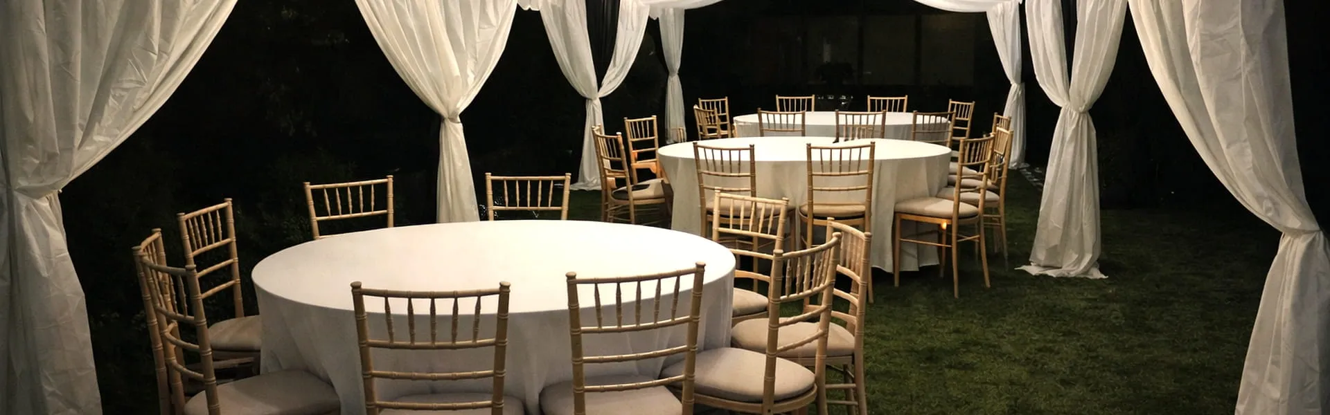 Marquee Evening Event Setup With Round Tables Evening marquee setup with round tables and chairs arranged for event planning