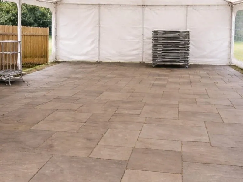 Marquee setup showing flooring installation and stacked equipment for event preparation