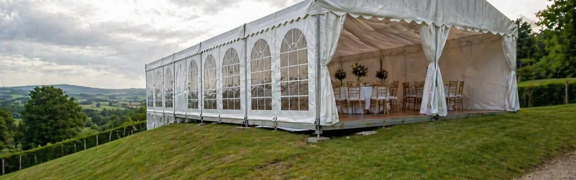 Marquee setup on sloping ground in Essex showing outdoor event tent installed on uneven hillside