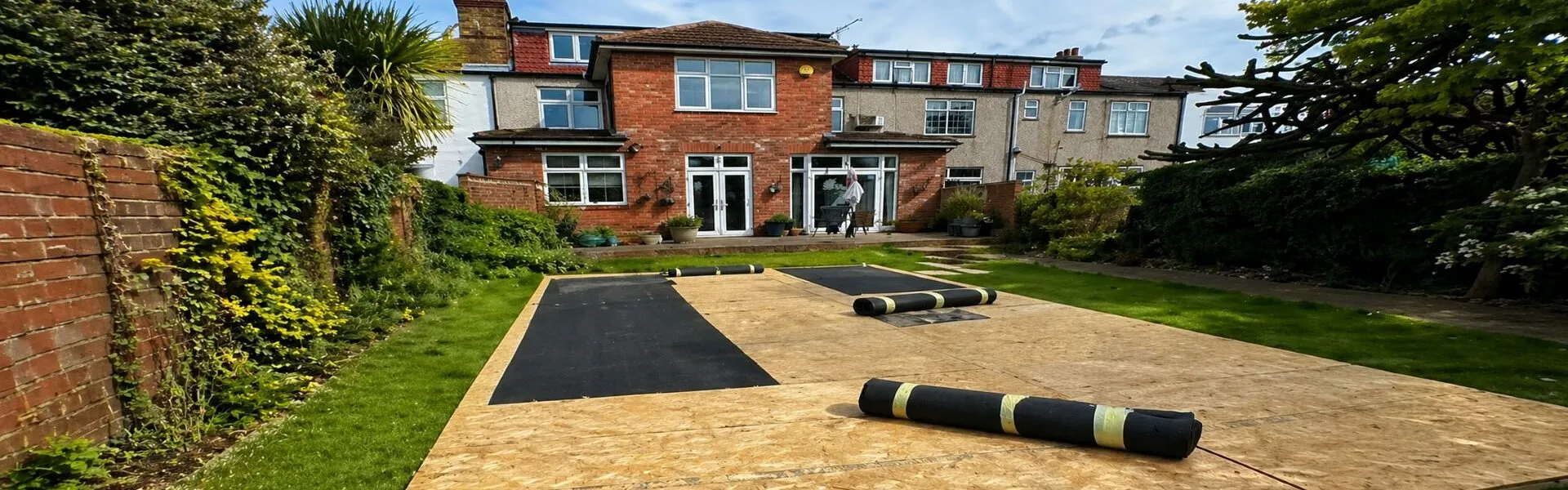 Marquee Setup Essex – Garden Flooring and Event Preparation Marquee setup in Essex garden showing flooring boards laid out for event installation and preparation