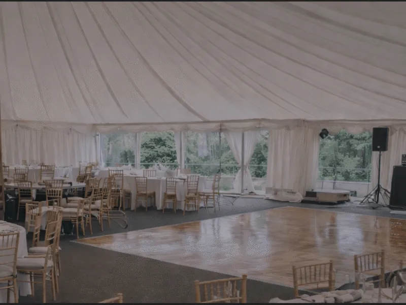 Marquee interior with dining tables and dance floor showing event layout space