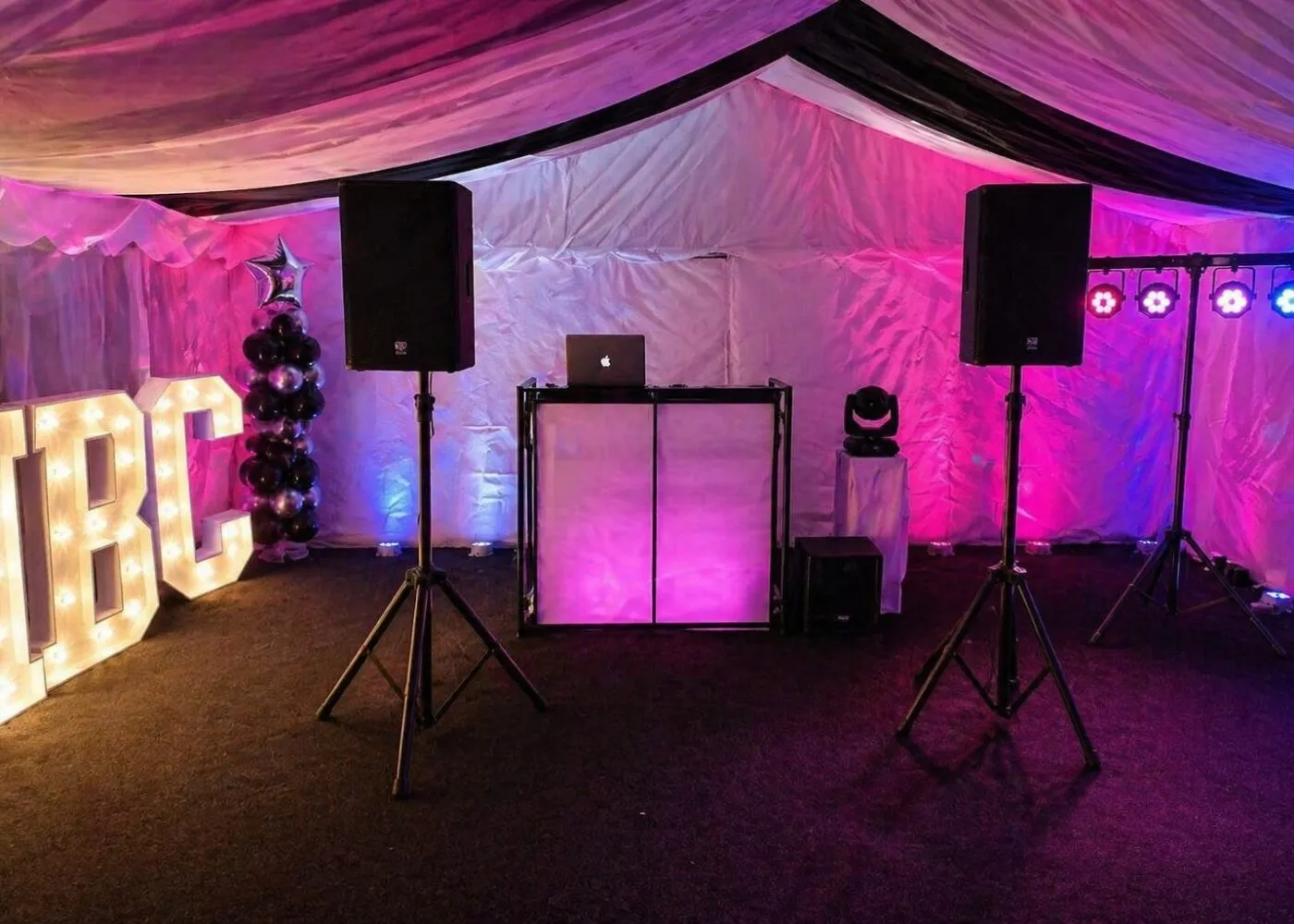 Speaker Hire Essex – DJ and PA System Setup Speaker and PA system hire setup in Essex with DJ booth, lighting and sound equipment inside marquee