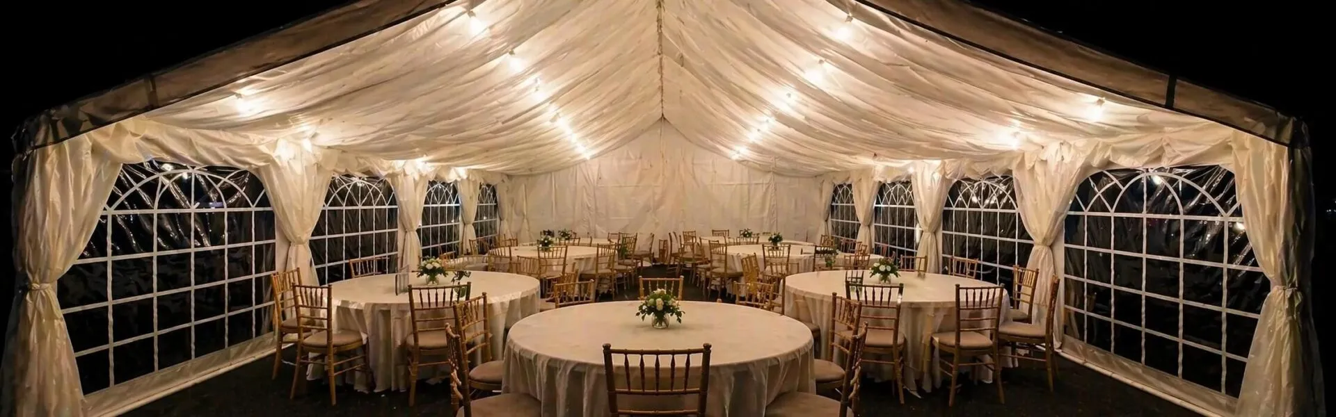 Marquee Interior Event Setup for Terms and Conditions Page Elegant marquee interior setup with round tables and lighting for event hire