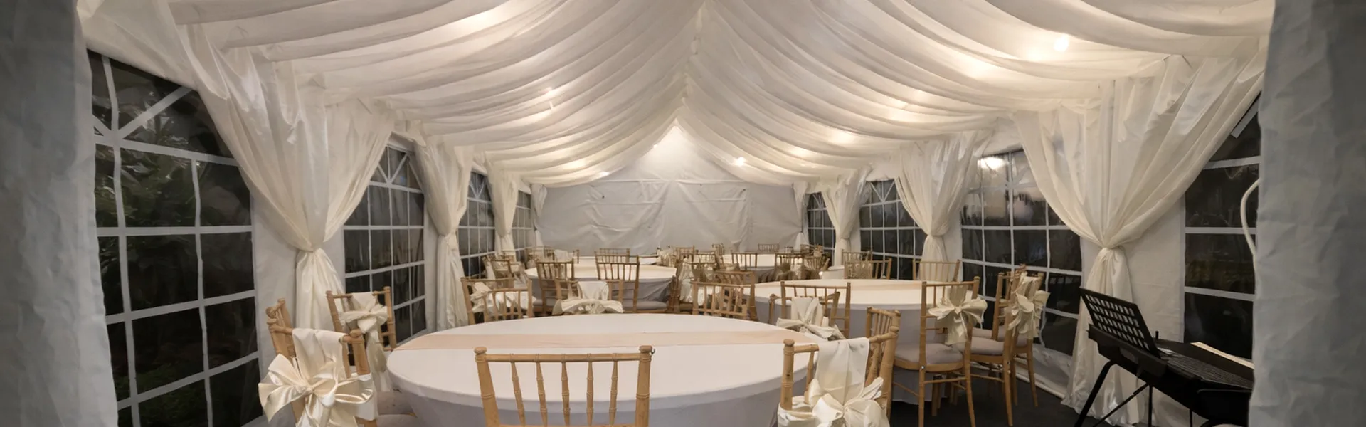 Wedding Marquee Setup With Round Tables And Draping Wedding marquee interior with round tables, ivory draping and decorated chairs for event setup