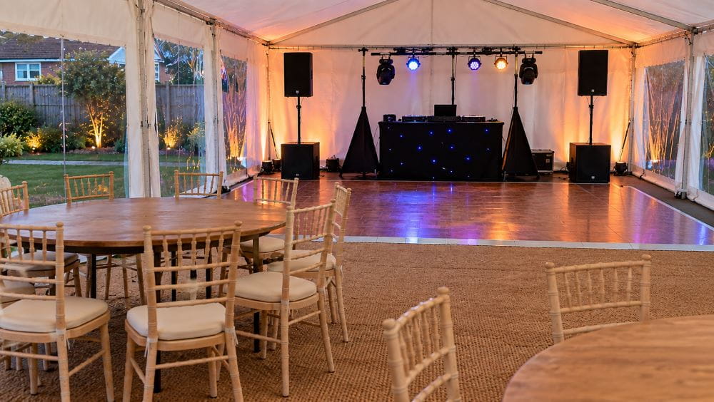 Garden marquee with separate DJ and speaker area away from event furniture