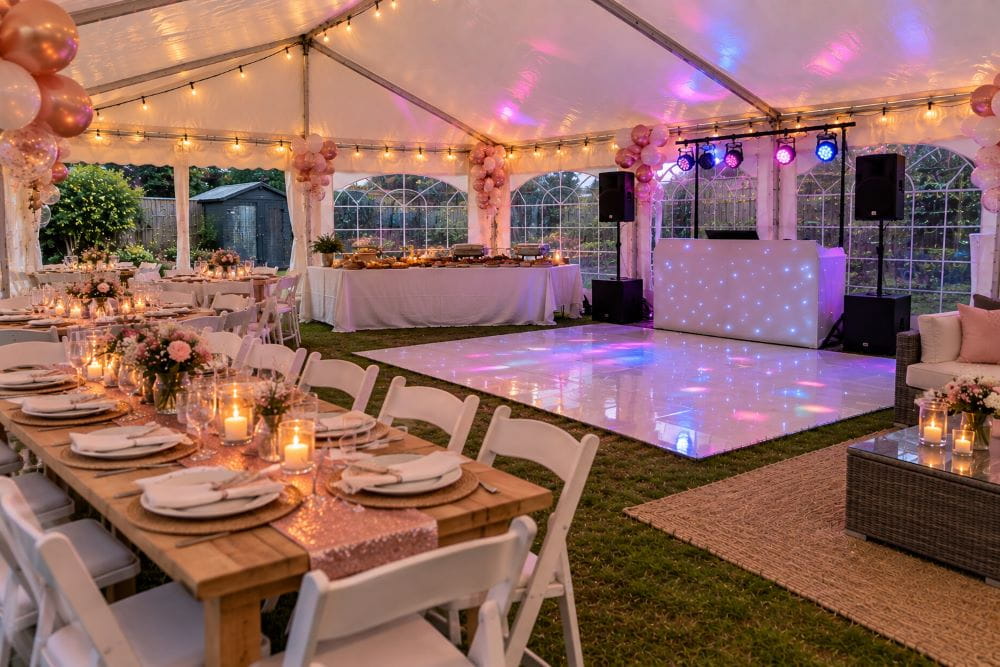 Garden party marquee with dining tables, buffet, DJ setup and dance floor