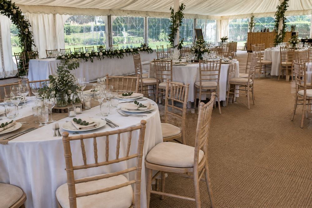 Wedding marquee tables and chairs arranged for dining and guest movement