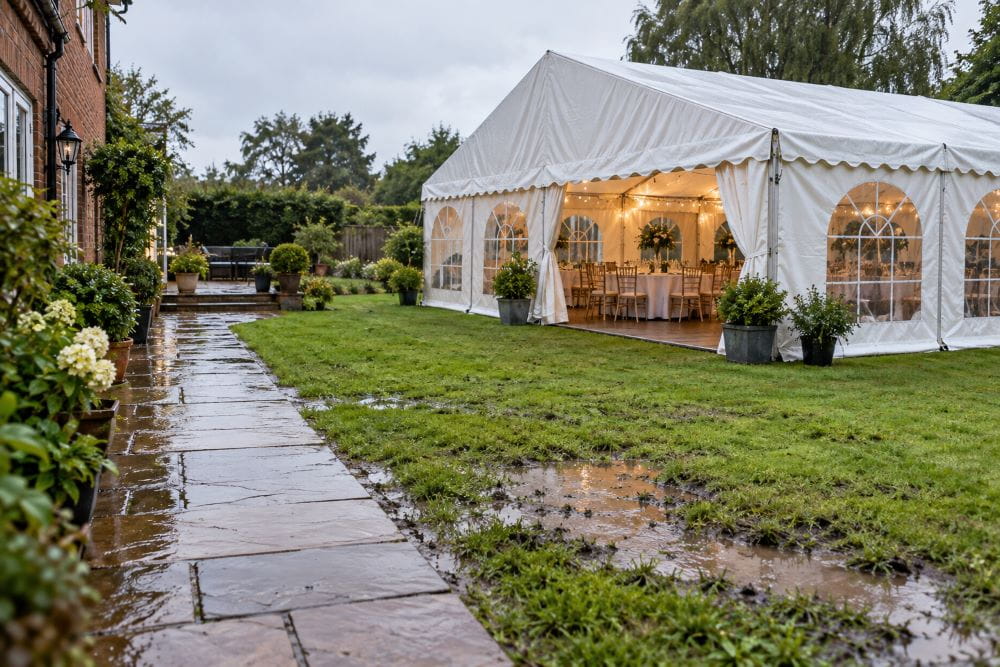Wet garden and guest route around a marquee after rain